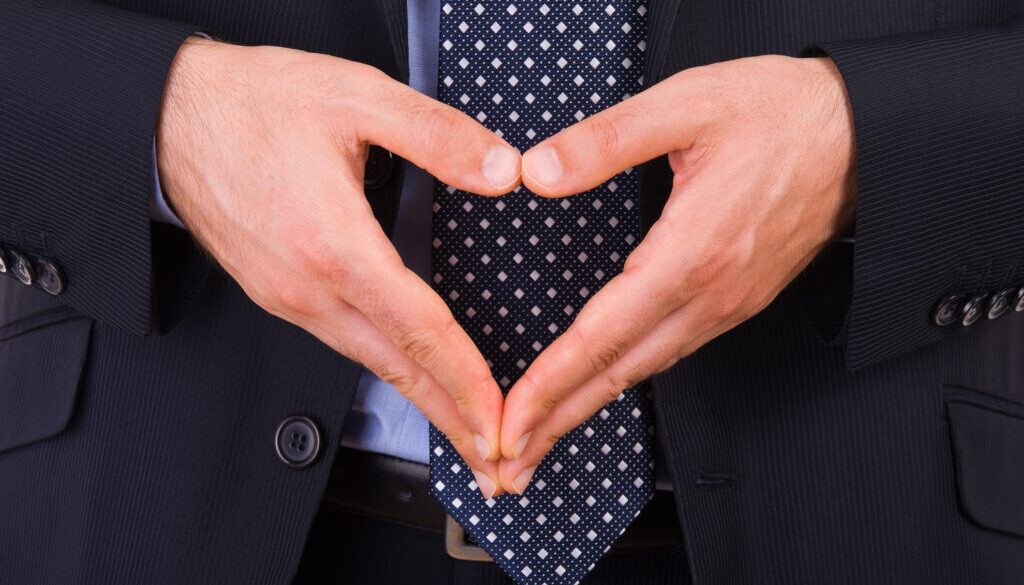 Businessman making heart symbol with hands.