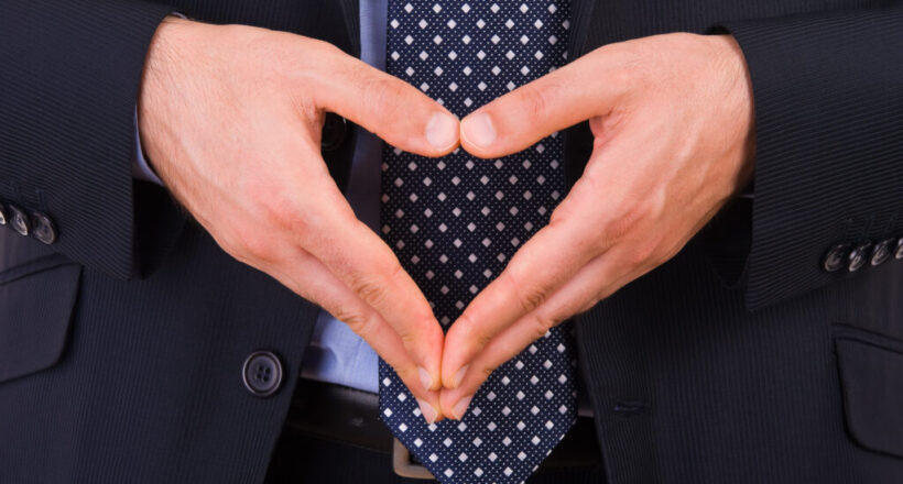 Businessman making heart symbol with hands.